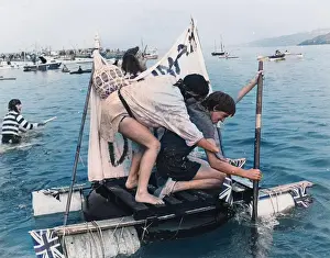 Two men competing in a raft race, St Ives, Cornwall
