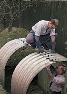 Spanner: Two men constructing an Anderson shelter