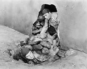 Fearful: Two men crawling out of a hole in a wall