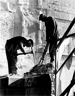 Demolishing: Two men demolishing a building