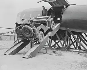 Freight: Men driving a jeep onto a plane at Fort Benning