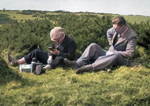 Picnicking: Two men enjoying a hilltop picnic