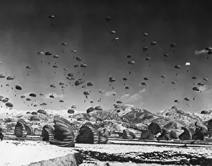 Parachuted: Men and equipment being parachuted to earth in