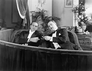 Formalwear: Two men in formal attire sitting together in a theater box