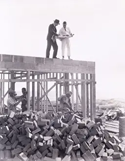Analyzing: Two men going over blueprints