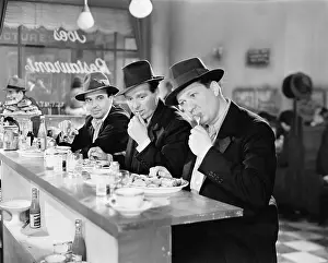 Greener: Three men with hats eating at the counter of a diner