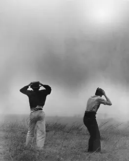 Topeka: Two men hold on to their hats during dust