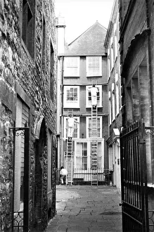 Mews: Men up ladders paint tall narrow building