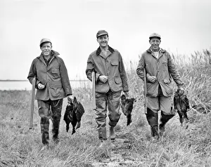 Shotguns: Three Men Looking at Camera Holding Shotguns Walking