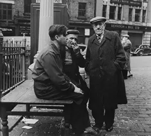 Cobblestones: Three men in a market square
