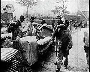 Stockpiles: Men Moving Small Artillery Shells Onto Large Stockpiles