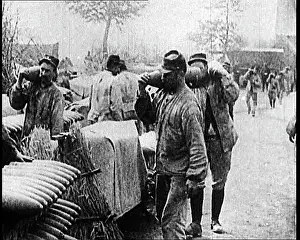 Stockpiles: Men Moving Small Artillery Shells Onto Large Stockpiles