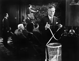 Securities: Men at a office one holding a ticker at the ticker machine