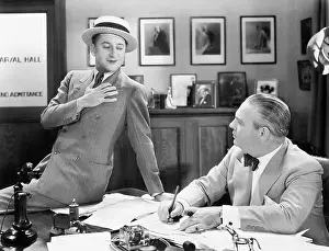 Smug: Two men in an office talking with each other