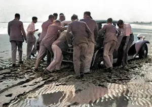 Breakdown: Men pushing car on wet beach