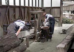 Planks: Two men sawing wood