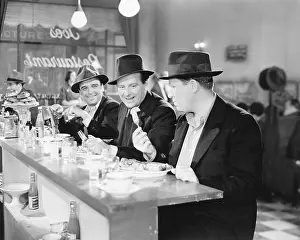 Side By Side: Three men sitting at the counter of a diner