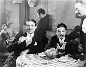 Everett Collection (old Visuals): Two men sitting together at a restaurant