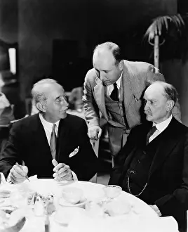 55 60: Three men sitting together at a table