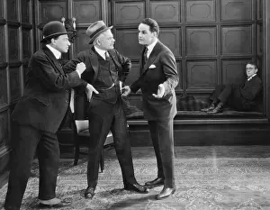 Confronting: Three men standing together arguing