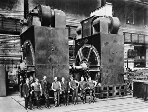 Generators: Nine men in suits are dwarfed by two massive ?