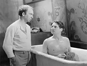 Bathrooms: Two men talking while one sitting in a bathtub