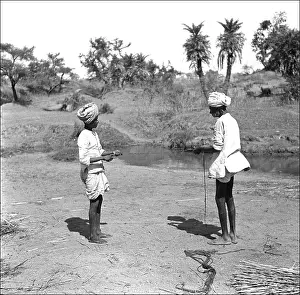 Bundles: Two Men tie reeds by a stream
