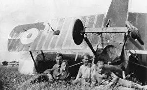 Upturned: Four men with upturned biplane in field, WW1