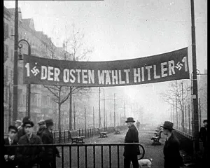 Wahlt: Men Walking Below Banner Reading - 1 Der Osten