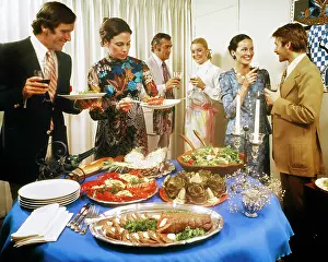 Fondue: Men and Women Around a Party Buffet Table Talking