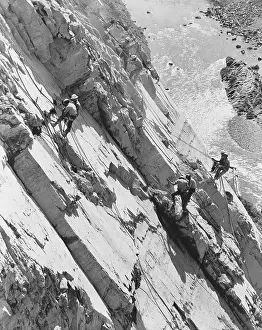 Drillers: Eight men working high up on rock face of canyon
