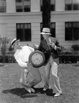 Timing: Two men wrestling with an oversized pocket watch