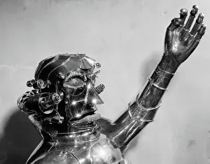 Robotics: Metal robot head and chest with one arm raised
