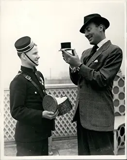 Hatted: Michael Wilding, actor, receives miniature hat, London