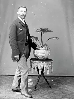 Uncomfortable: Middle aged man with potted palm, Mid Wales