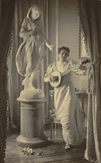 Pictorialism: Miss Apperson playing banjo beside statue ?
