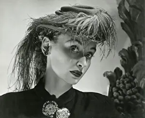 Brooches: Model in jaunty small hat with elaborate feathers