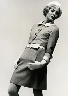 Leans: Model in mini skirt suit, with white beret and gloves