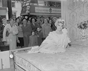 Babydoll: Model poses on bed in shop window, Bexley