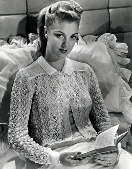 Pillow: Model sitting in bed on a large silk pillow, reading a novel