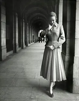 Pleated: Model standing at end of a covered walkway - two-piece suit