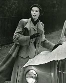 Sophistication: Model in striped long woollen coat reading a map