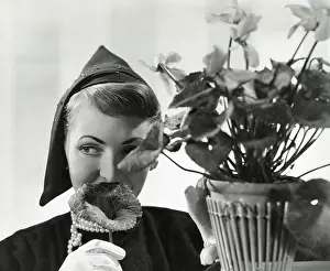 Millinery: Model wearing an unusual pointed soft cap and cyclamen