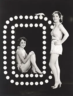 1910s 1940s: Two models posing by large letter O