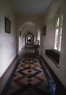 Colin Horsman: Monastic life - nun sits reading in a tiled corridor