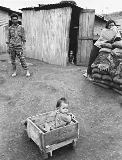 Makeshift: A Montagnard child in a makeshift wagon is watched