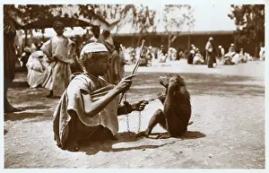 Skullcap: Moroccan boy (trainer) with monkey