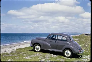 Wanderlust: A Morris Minor parking on grass overlooking Traeth Llanddwyn