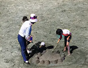 Andrew Besley: Mother and children making sandcastle