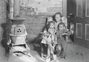 Stove: Mother and her two children sitting by wood